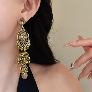 Close-up detail of vintage gold court style dangle earring with rhinestones on Asian model