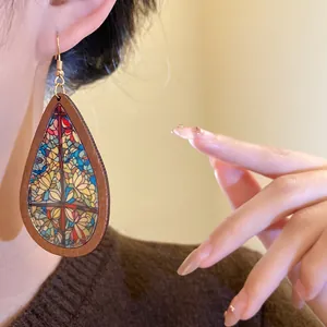 Detailed close-up view of Bohemian wood print water drop earrings worn on an ear