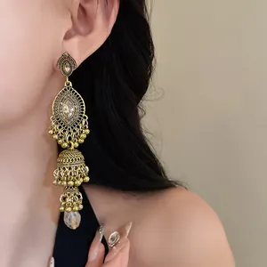 Close-up view of the intricate vintage gold filigree and rhinestone earring detail