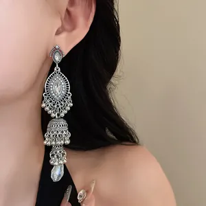 Close-up of vintage palace-style silver-toned drop earrings with clear rhinestones