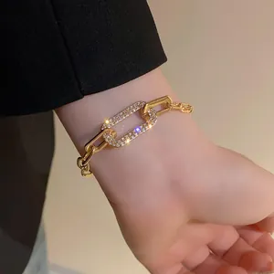 Detailed view of elegant gold chain bracelet featuring a large pavé rhinestone link