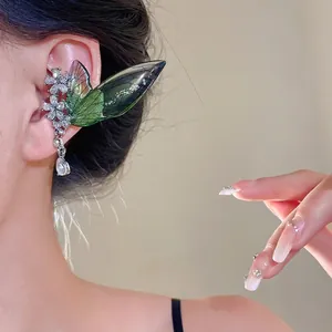 Elegant rhinestone ear cuff featuring shimmering green insect wings and floral crystal accents