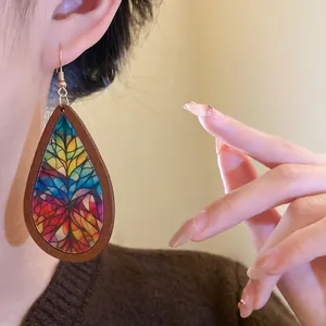Detail of Bohemian teardrop wooden earring with colorful stained-glass floral pattern