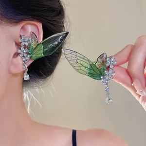 Detailed view of green fairy wing ear cuffs with sparkling floral crystals and drop pendants.