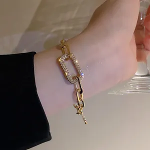 Detail view of a vintage geometric gold chain bracelet with pavé rhinestones on wrist.