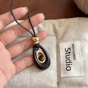 Tiger eye stone resin oval pendant necklace on studio background