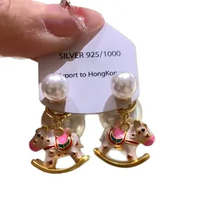 Elegant white enamel rocking horse earrings with pearl accents and 925 silver posts.