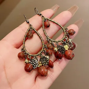 Vintage teardrop earrings with antique bronze metal frames and reddish brown stone beads