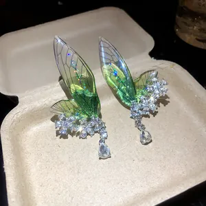 Macro view of green translucent wing ear cuff featuring intricate crystal flower details