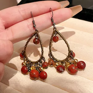 Macro detail of vintage teardrop earrings with red natural stone beads