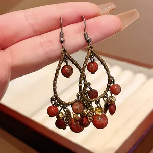 Detail view of vintage neo-Chinese style water drop earrings with red stone beads