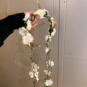 Macro detail showing a Mori style flower garland headband with white petals and leaves