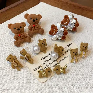 Detailed view of various flocked bear earrings featuring pearls, crystals, and gold accents
