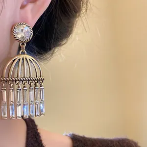 Detailed close-up showing a vintage gold cage tassel earring with clear zircon crystals