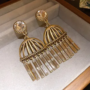 Detail of vintage gold-tone earrings with round and rectangular zircon crystals in box