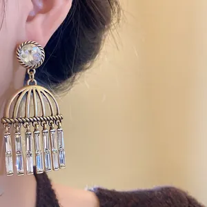 Close-up of vintage zircon tassel earrings with hollow bell design and rectangular stones