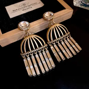 Detailed macro shot of vintage gold hollow cage earrings featuring sparkling zircon tassels