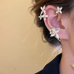 Élégant contour d'oreille fleur en argent avec strass brillants porté par un modèle