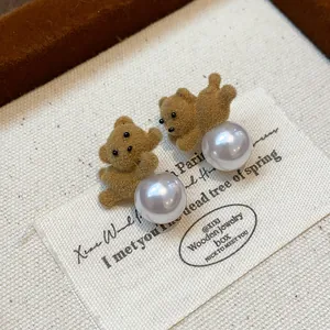 Detailed close-up of cute flocked brown teddy bear pearl stud earrings displayed on a vintage card
