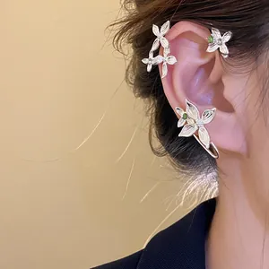 Vue détaillée d'une manchette d'oreille florale en argent avec des strass étincelants.