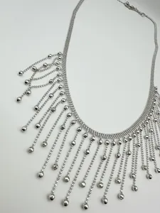 Vue macro détaillée d'un collier argenté à plusieurs rangs avec franges en perles fines