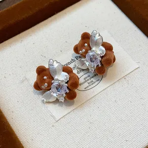 Detailed view of 18K gold plated flocked bear stud earrings with sparkling crystal wings