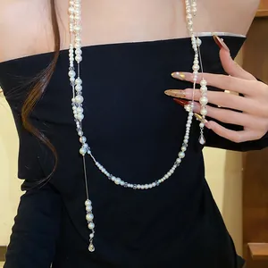 Detailed view of a double-layered pearl necklace with sparkling rhinestone teardrop pendant
