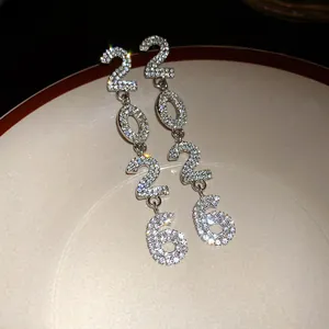 Macro shot of sparkling rhinestones on numerical 2026 earrings showcasing fine craftsmanship.