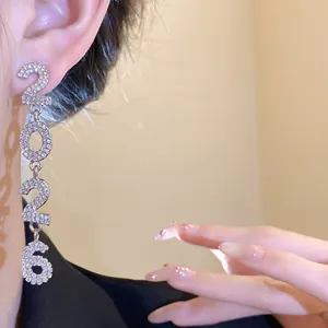 Close-up detail of silver rhinestone dangle earrings featuring 2026 number design.