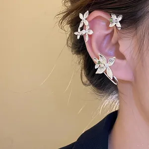 Détail élégant d'un bijou d'oreille fleur en strass argentés sur un mannequin d'Asie