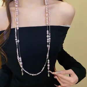 Detail view of a vintage double-layered pearl necklace with teardrop pendants on a model