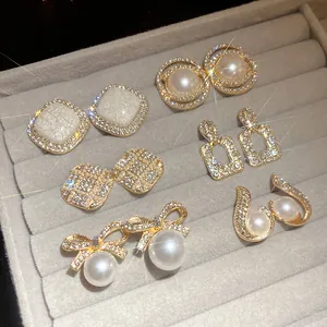 Detailed macro view of various vintage-style gold earrings with pearls and crystals