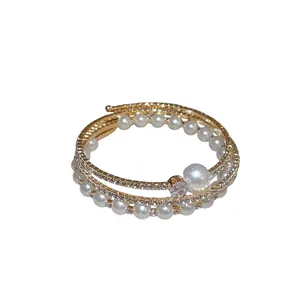 Elegante bracciale rigido dorato multistrato con perle e strass, stile vintage aperto