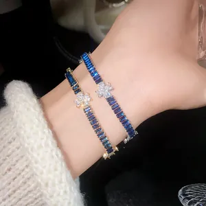 Detailansicht luxuriöser blauer Zirkon-Armbänder mit eleganten klaren Blumenanhängern am Handgelenk