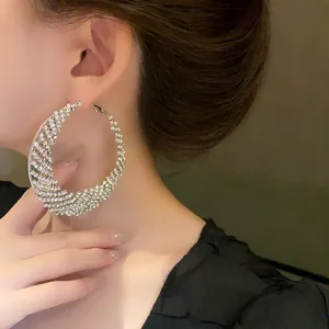 Elegantes pendientes de aro de media luna de plata con pavé de cristales brillantes