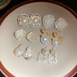 Macro view showing vintage-style pearl and rhinestone earring assortment on a plate