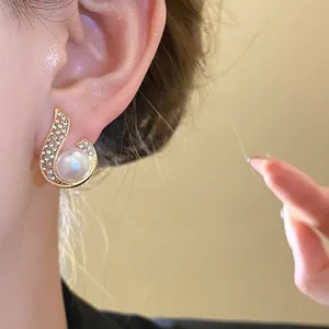 Detailed view of a French vintage earring with a white pearl and sparkling rhinestones.