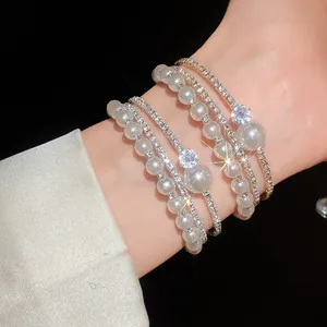 Vista dettagliata di un elegante bracciale multistrato con perle e strass luccicanti.