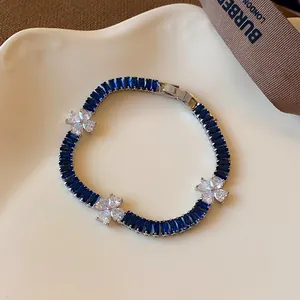 Detaillierte Makroansicht eines eleganten Blumenarmbands mit blauen und weißen Zirkonia.