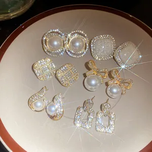 Detailed view of multiple vintage French style pearl and rhinestone gold earrings