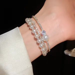 Vista dettagliata di un elegante bracciale rigido multistrato con perle e strass