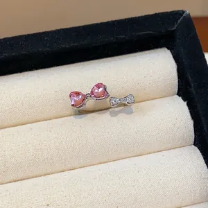 Dettaglio di un anello aperto argento con fiocco a cuore rosa e cristalli