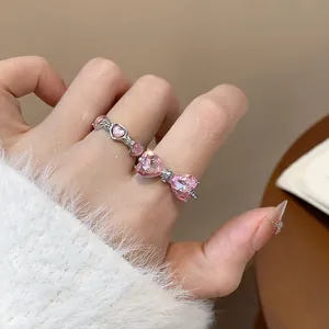 Primo piano di un anello regolabile argento con un elegante fiocco di cuori rosa