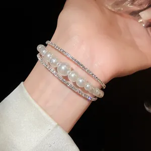 Primo piano di elegante bracciale argento multistrato con perle e strass luccicanti