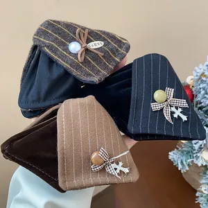 Vue détaillée des pinces à cheveux triangulaires en tissu rayé avec nœuds et perles
