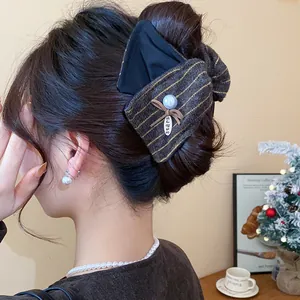 Vue détaillée de dos d'une grande pince à cheveux en tissu dans un chignon élégant