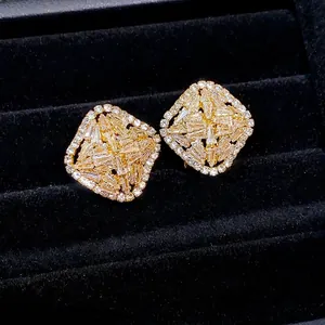 Elegant lozenge-shaped gold earrings with sparkling cubic zirconia on black velvet