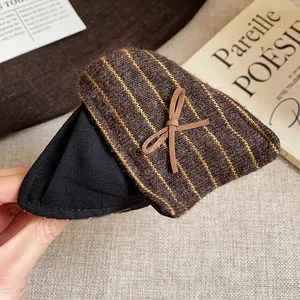 Détail macro de la pince à cheveux triangle en tissu rayé marron avec un petit nœud