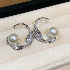 Elegantes pendientes de aro de hoja retorcida plateada con perlas grandes en bandeja