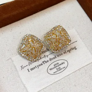 Detailed close-up of elegant French style rhombus zirconia stud earrings in gold finish.